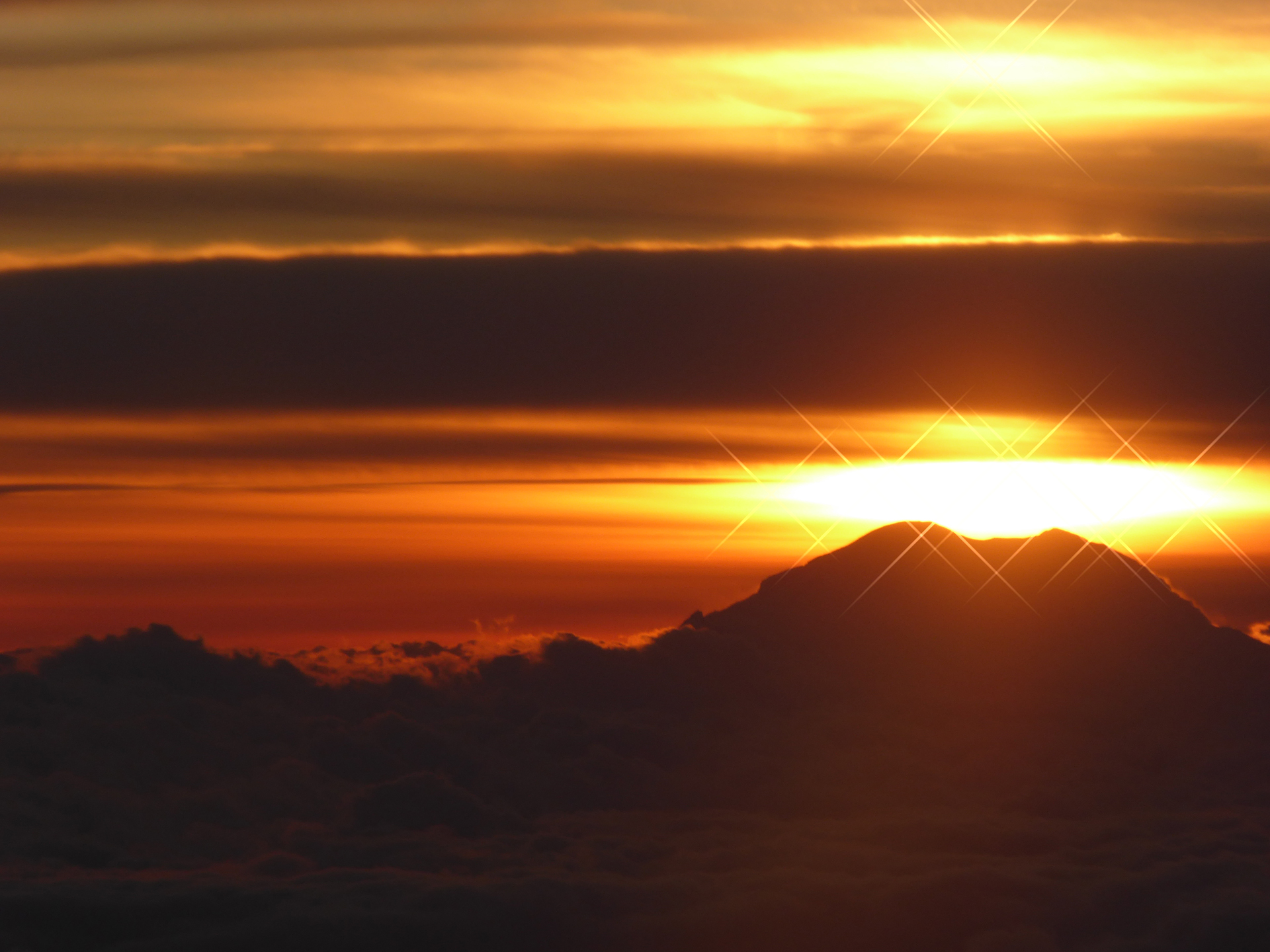 Photograph of the setting Sun over Mount Rainier.